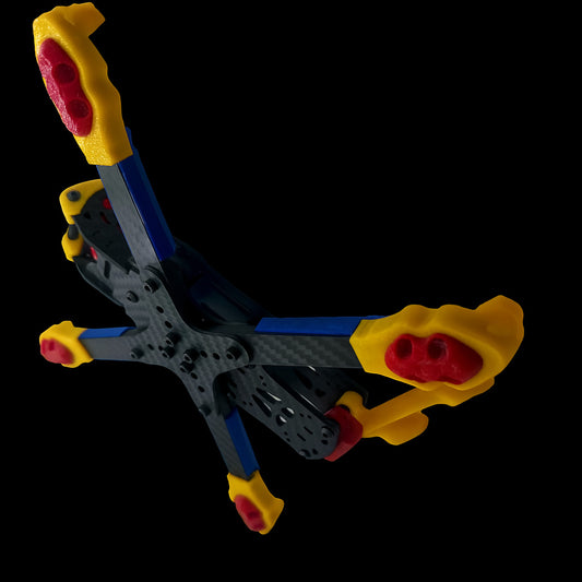 lyclops 3D printed accessory kit mounted on ILLmatic FPV frame, featuring yellow and red bumper guards with blue arm protectors rugged protection for freestyle rigs like TANQ,  Vannystyle, Syncmode, Flipmode, Apex, and ERA.