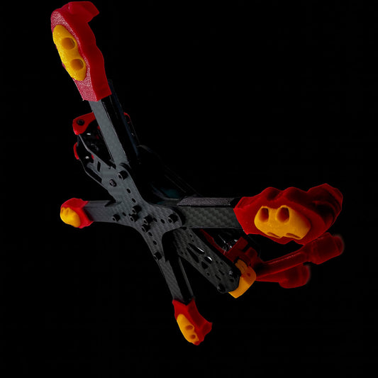 Close-up side angle of Shredpool freestyle protection kit featuring red and yellow TPU components on the ILLmatic frame, built for aggressive flying and crash resistance.